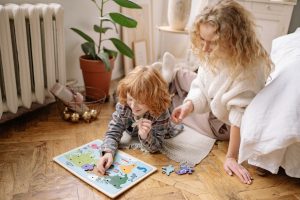 dziecko układające puzzle z mamą